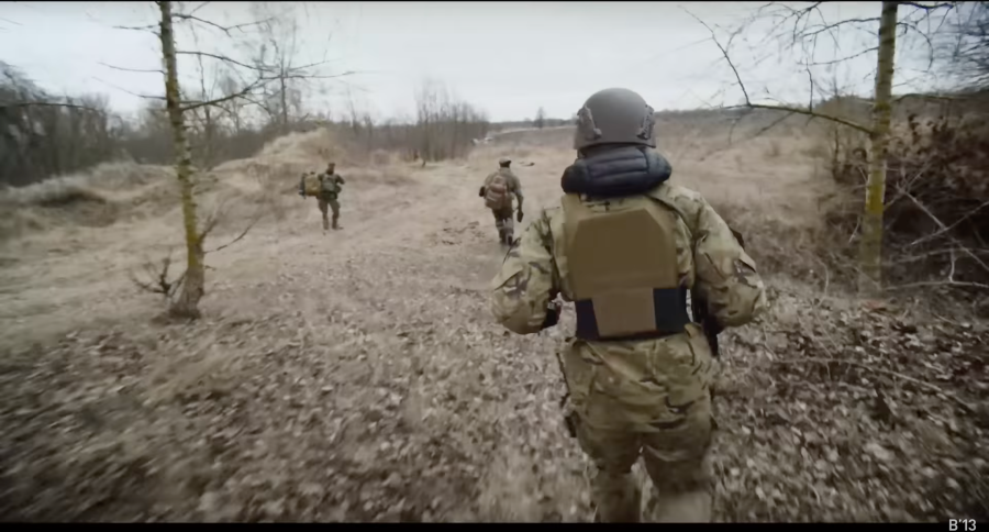 3 male soldiers running through the woods